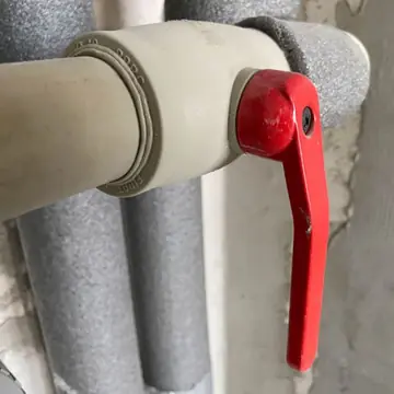 Tubulação com isolamento térmico e registro de alavanca vermelho em encanamento de água fria